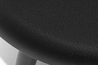 Close-up of dark black stool on a white surface.